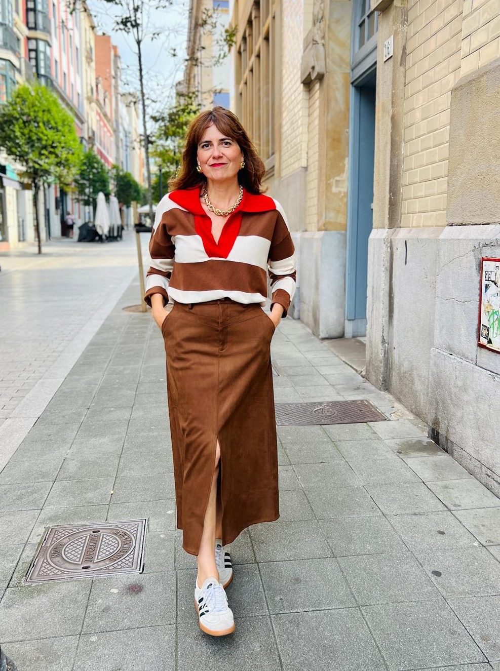 falda polipiel marrón glaieul frnch y jersey de rayas marrones y crudas con cuello polo rojo colchique